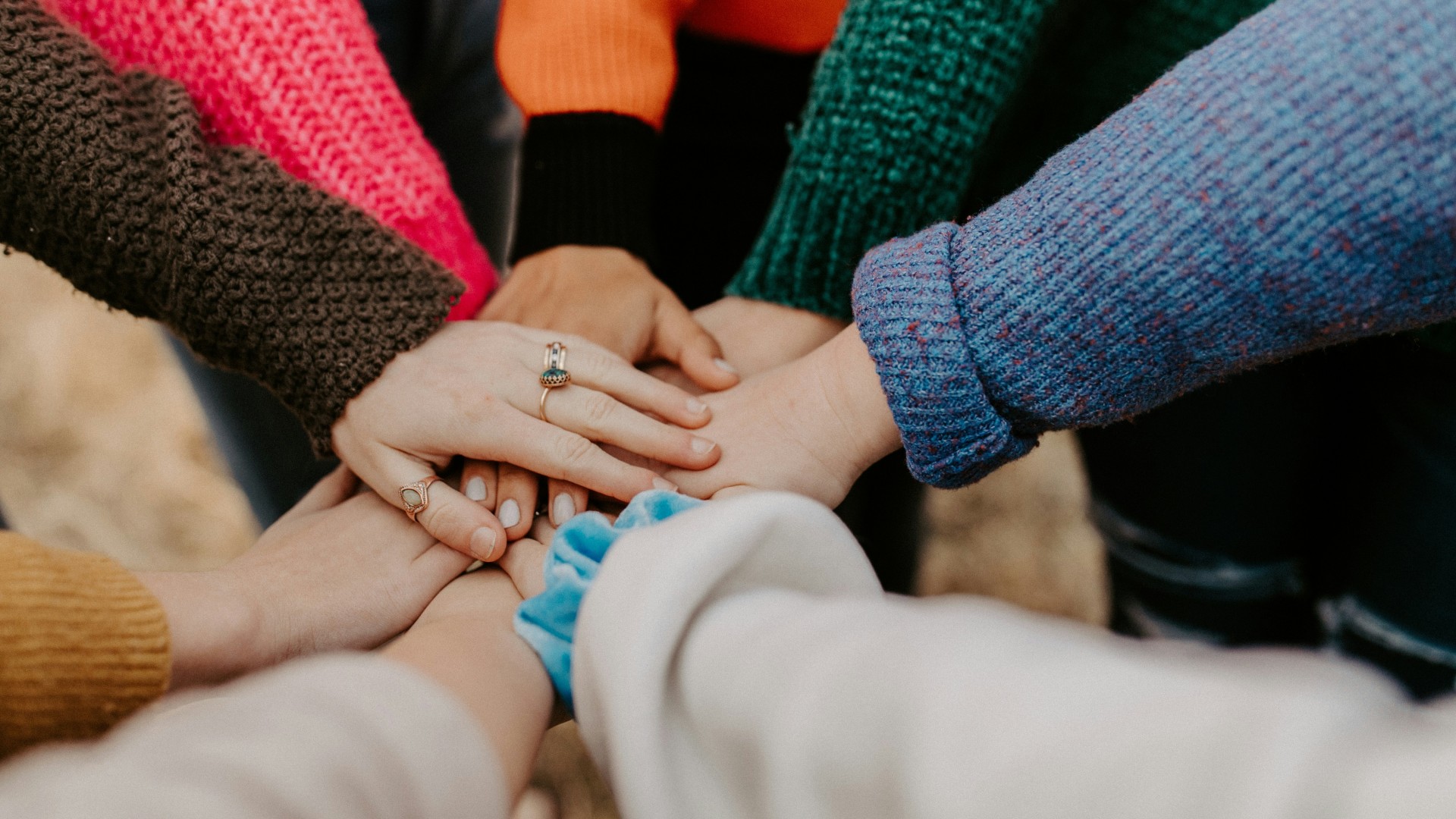Hands on top of one another in a circle of women.