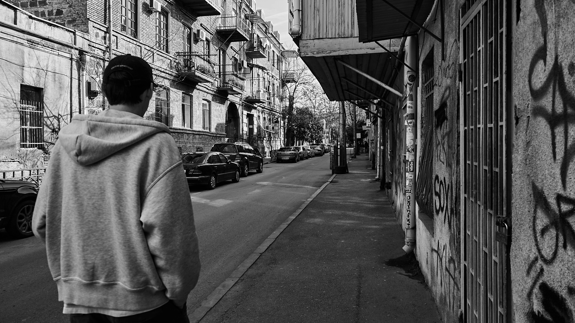 Un ragazzo caminando per una strada in una grande città.