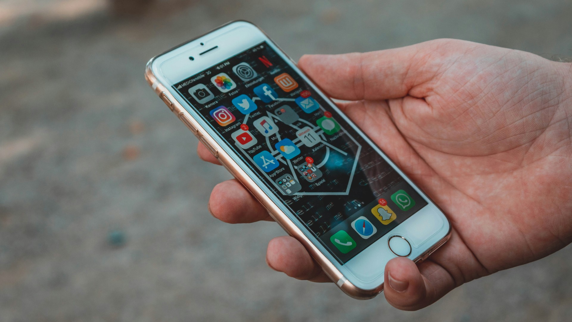 Foto di uno smartphone con le app di social media, nella mano di una persona.