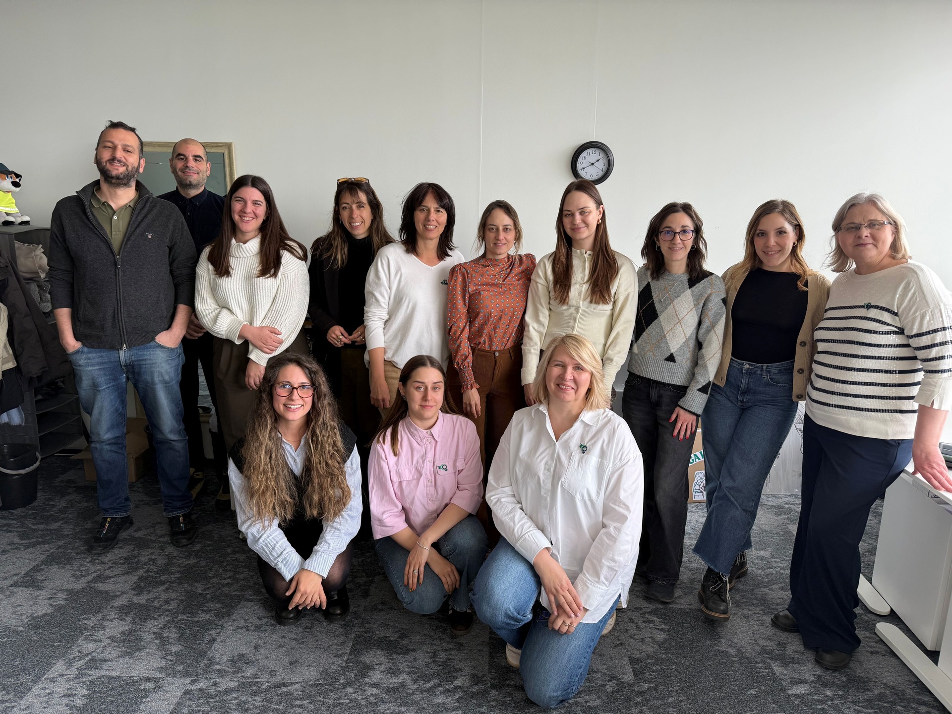 Il team del progetto BREAK riunito durante il primo incontro europeo a Vilnius, aprile 2026. Un gruppo di tredici persone posa per una foto ricordo in una stanza luminosa. Alcune sono in piedi, tre sono in primo piano in basso. Tutti sorridono.