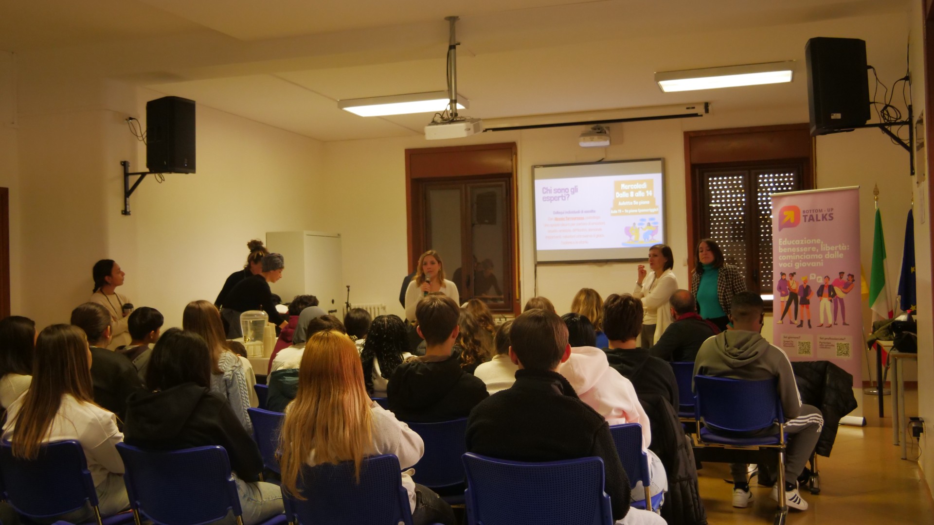 Persone giovani e adulte che ascoltano delle relatrici all'evento di inaugurazione dello sportello di ascolto.