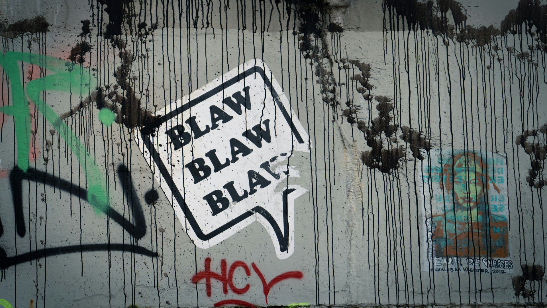 Testo 'blaw blaw blaw' su un muro con graffiti.