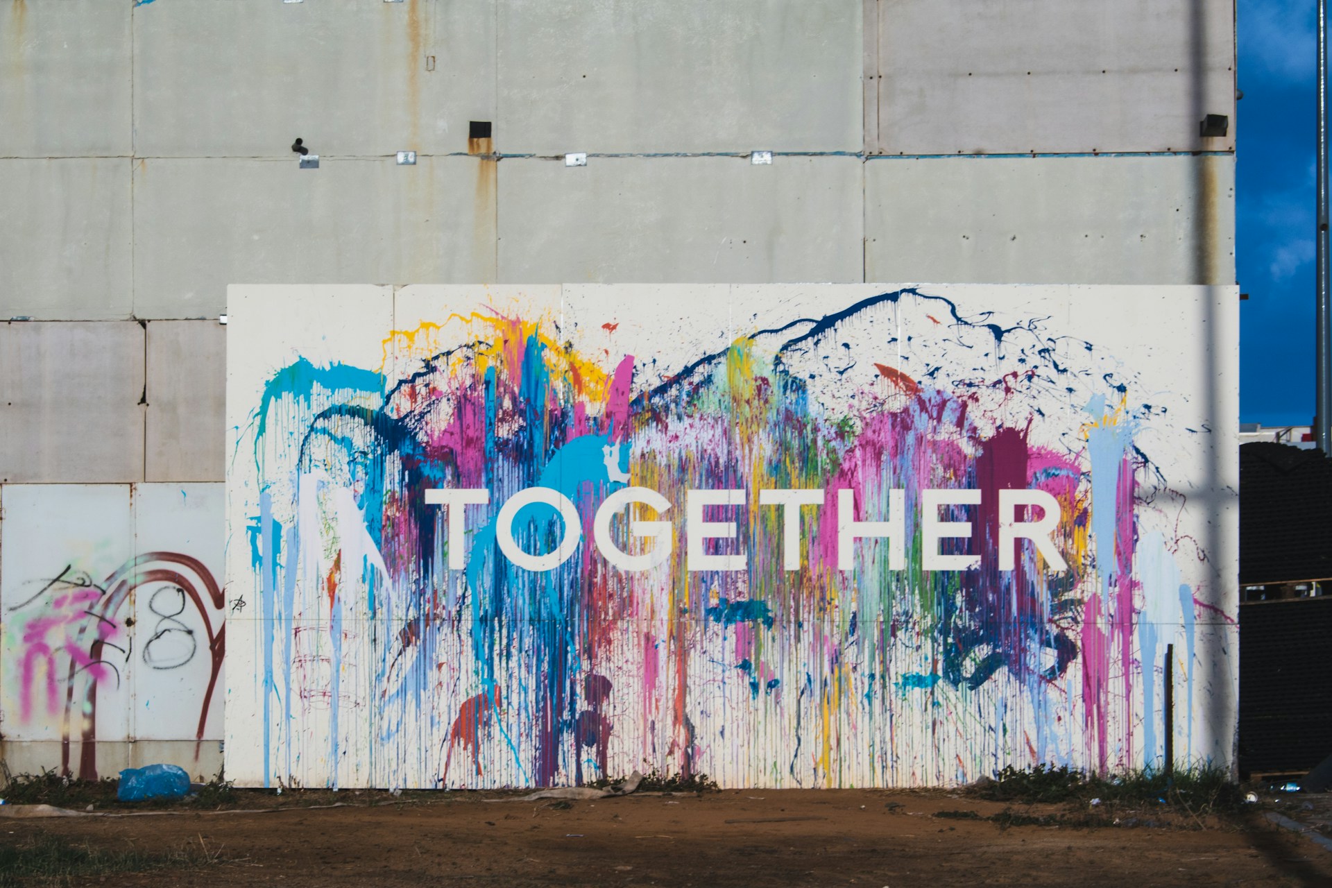 la parola 'together' scritta su una parte di muro colorata con tanti vernici.