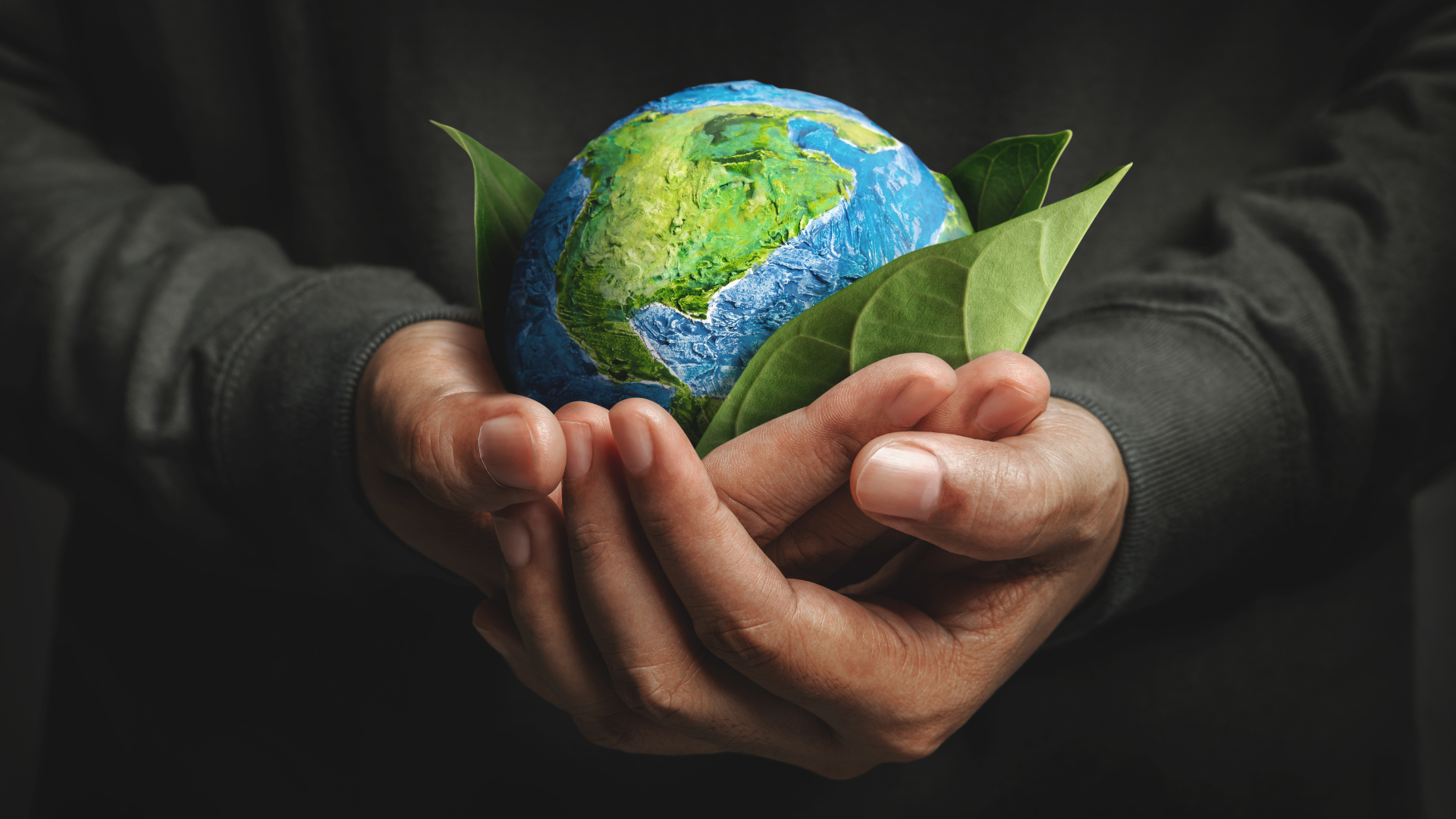 Persona ha tra le mani il pianeta terra e lo sorregge con cura come se fosse un frutto